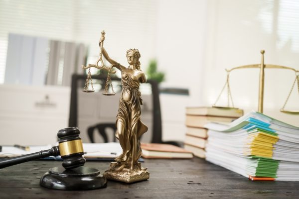 A lawyer's desk in the office is filled with legal documents.The lawyer provides consultations